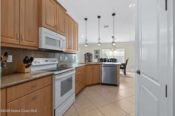 a living room with furniture a flat screen tv and kitchen view
