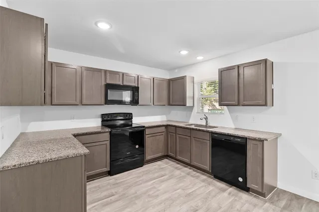 a kitchen with stainless steel appliances granite countertop wooden cabinets sink and stove top oven