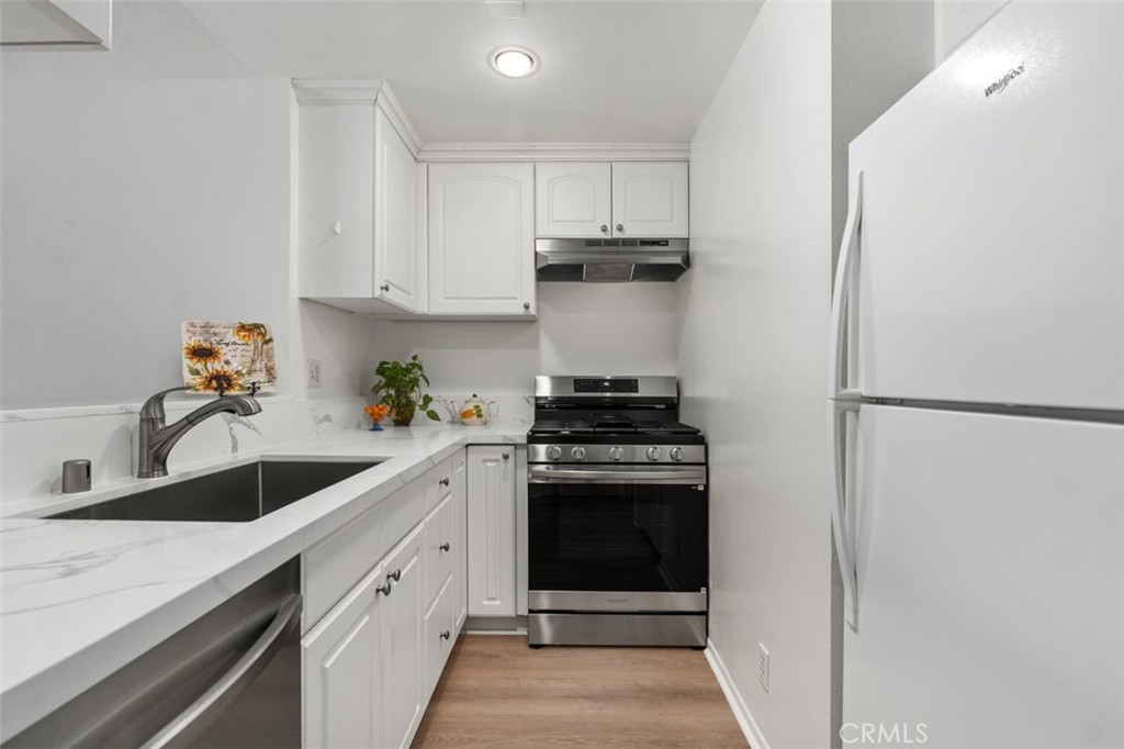 89 Lemon Grove Irvine, CA 92618 - Photo 9 of 34 a kitchen with white cabinets and white appliances