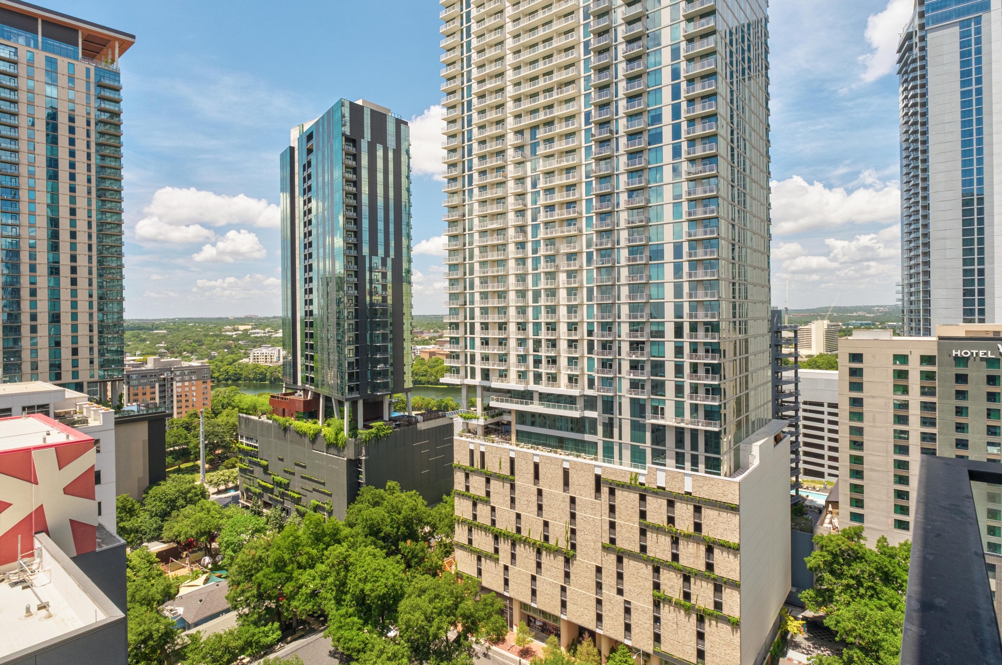 84 East Avenue, Unit 2008 Austin, TX 78701 - Photo 23 of 23 City skyline views from a soaring skyscraper, showcasing lush greenery amidst urban architecture.