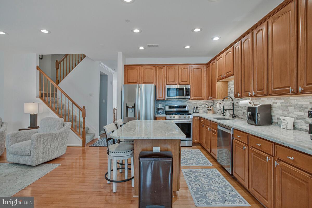 3515 Cromarty Lane Edgewater, MD 21037 - Photo 7 of 53 a kitchen with stainless steel appliances kitchen island granite countertop a refrigerator a stove a sink dishwasher and a microwave with wooden floor