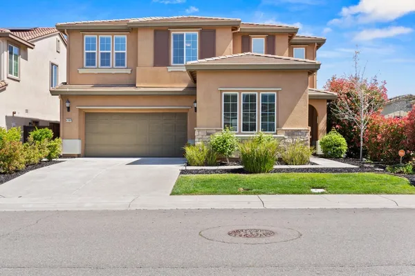 a front view of a house with a yard and a garage