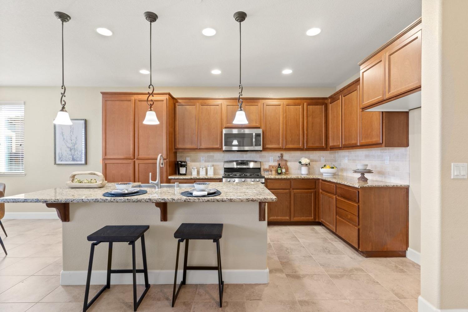 6307 Lookout Pass Way Rocklin, CA 95765 - Photo 14 of 72 a kitchen with stainless steel appliances granite countertop a stove sink and cabinets