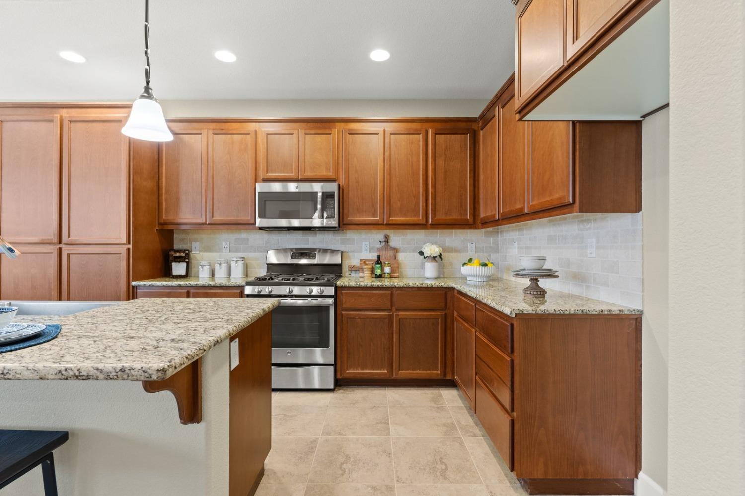 6307 Lookout Pass Way Rocklin, CA 95765 - Photo 16 of 72 a kitchen with stainless steel appliances granite countertop a stove top oven a sink dishwasher and a refrigerator