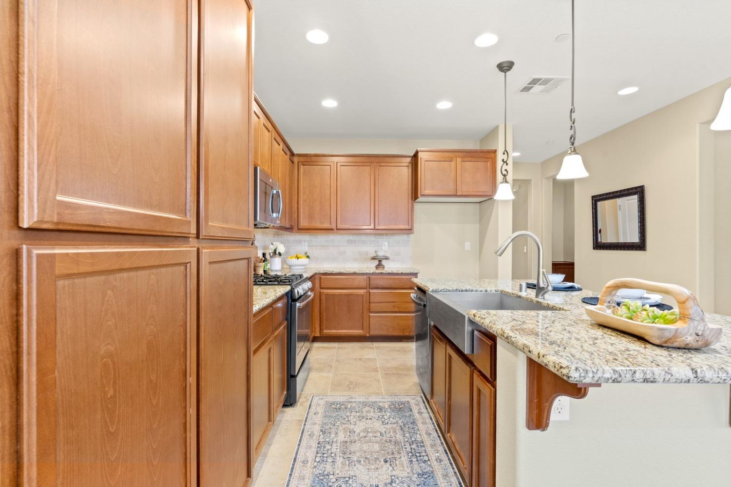 6307 Lookout Pass Way Rocklin, CA 95765 - Photo 19 of 72 a kitchen with stainless steel appliances granite countertop a sink and stove
