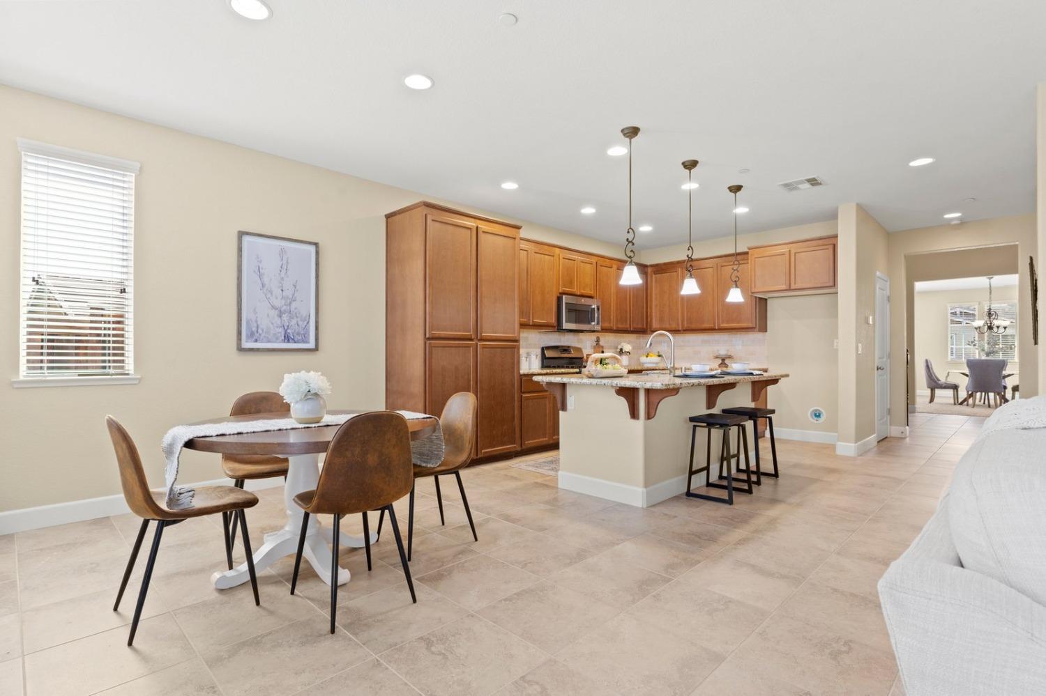 6307 Lookout Pass Way Rocklin, CA 95765 - Photo 28 of 72 a room with stainless steel appliances kitchen island granite countertop a dining table chairs and a refrigerator