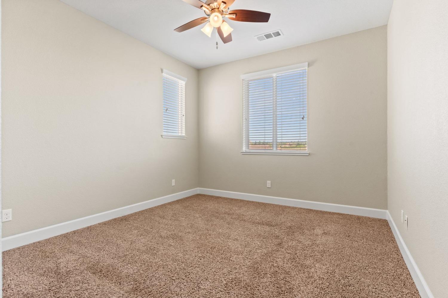 6307 Lookout Pass Way Rocklin, CA 95765 - Photo 54 of 72 an empty room with a chandelier fan and windows