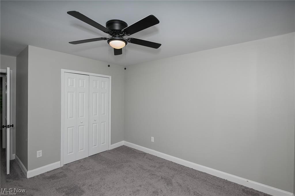 7613 Jefferson Road Ashtabula, OH 44004 - Photo 26 of 35 Unfurnished bedroom with ceiling fan, carpet floors, and a closet
