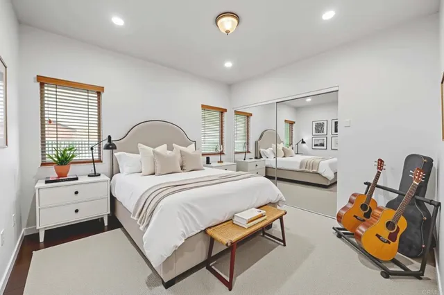 a living room with furniture hard wood floor and a floor to ceiling window