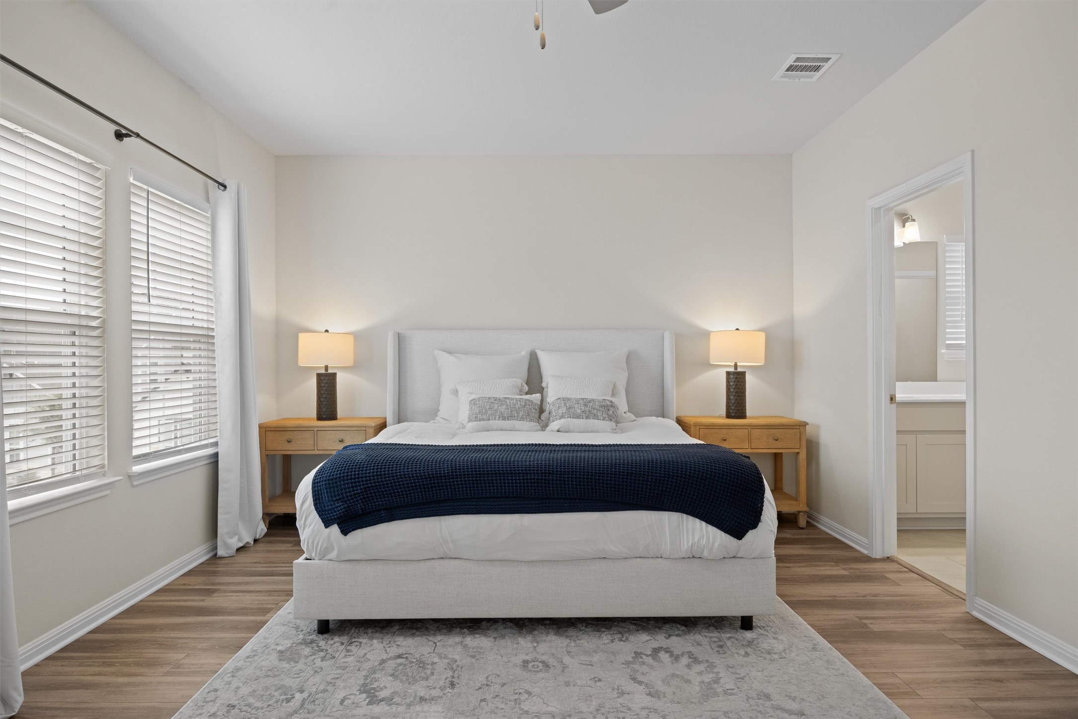 313 Toddy Way Leander, TX 78641 - Photo 15 of 39 Bedroom with wood finished floors, ceiling fan, and ensuite bathroom