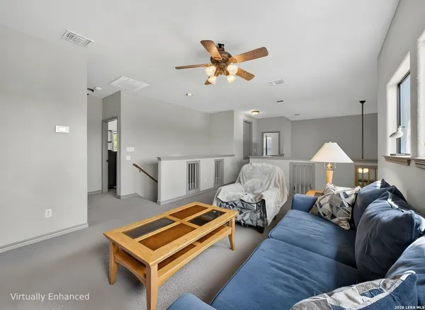 a living room with furniture a ceiling fan and a window