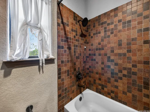 a bedroom with a bed chandelier and a window