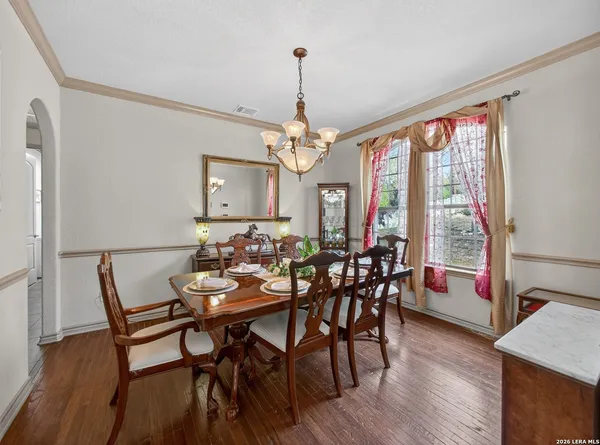 a view of a dining room with furniture a chandelier and wooden floor