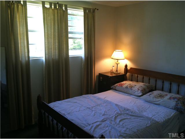 2620 Old Williams Road Raleigh, NC 27610 - Photo 12 of 17 a bedroom with a bed and a lamp