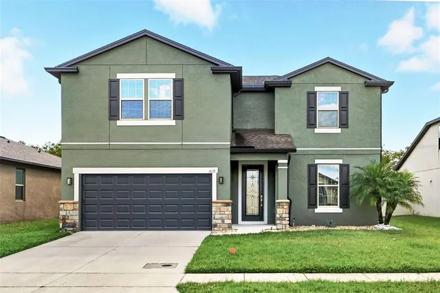 a front view of a house with a yard and garage