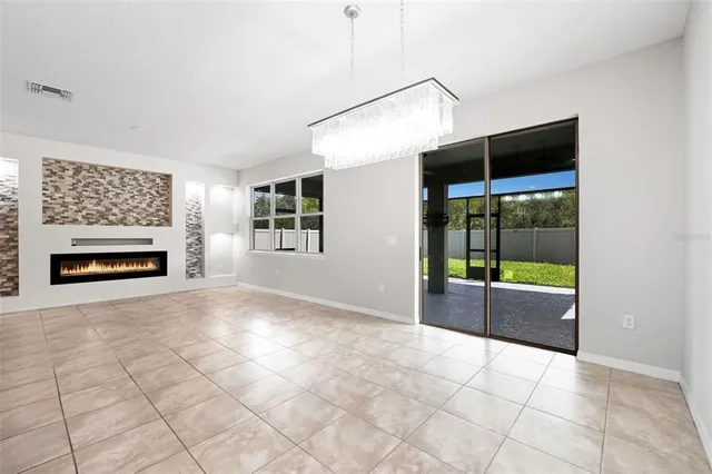 a view of empty room with floor to ceiling window and fireplace