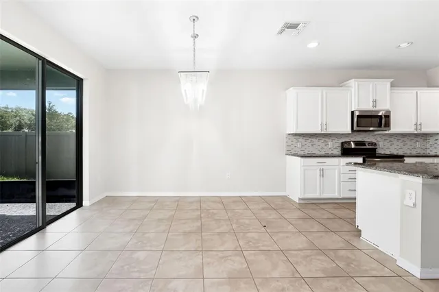 a kitchen with granite countertop a stove a sink and a refrigerator