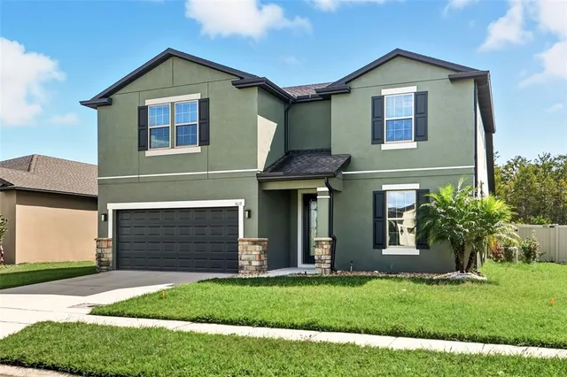 a front view of a house with a yard and garage