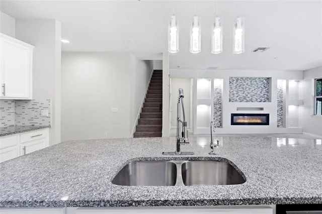 a kitchen with a sink a counter space and cabinets