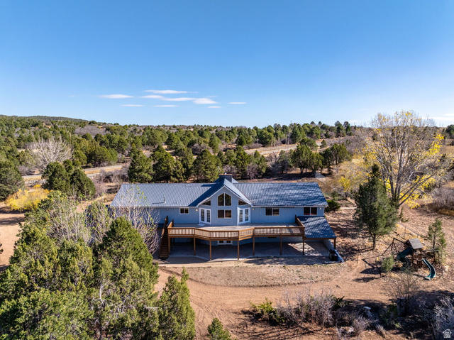 Rear view of property featuring stairs and a metal roof