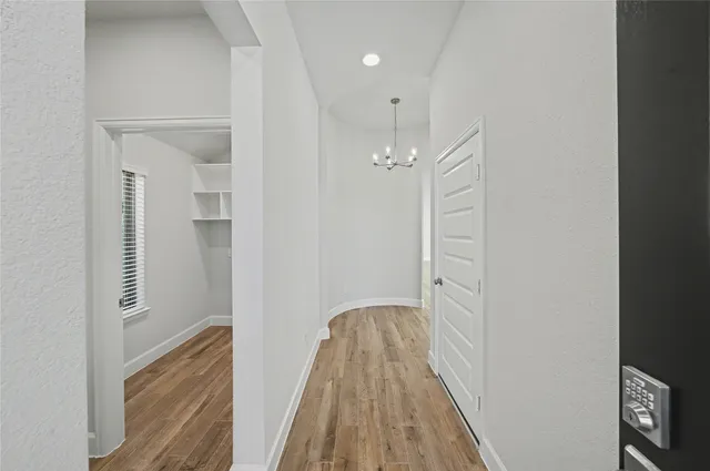 a view of a hallway with wooden floor and closet