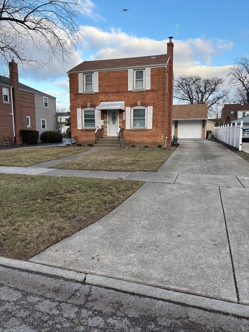 a view of a brick house with many windows next to a road
