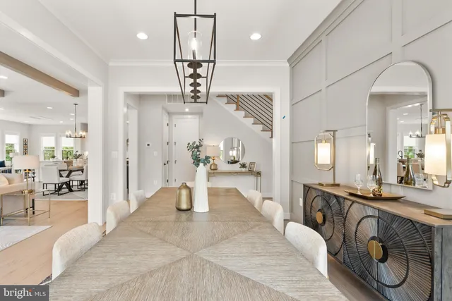 a large kitchen with stainless steel appliances kitchen island granite countertop a sink a stove a refrigerator and a dining table with wooden floor