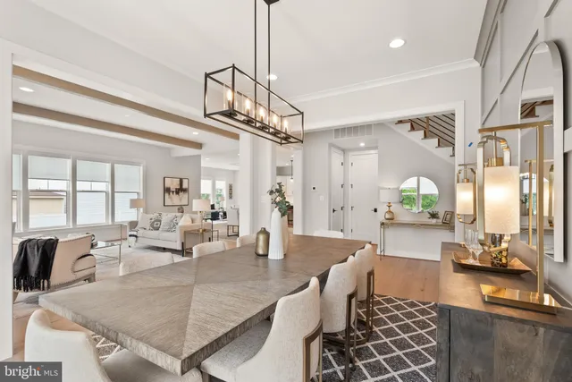 a kitchen with stainless steel appliances kitchen island granite countertop a table chairs and a refrigerator