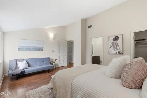 a bedroom with a large bed couch and a window