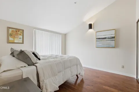 a bedroom with a bed and a painting on the wall