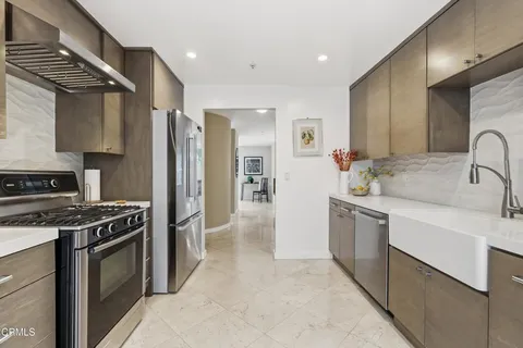 a kitchen with stainless steel appliances granite countertop a sink stove and refrigerator
