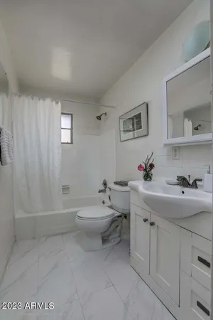a spacious bathroom with a toilet sink and mirror