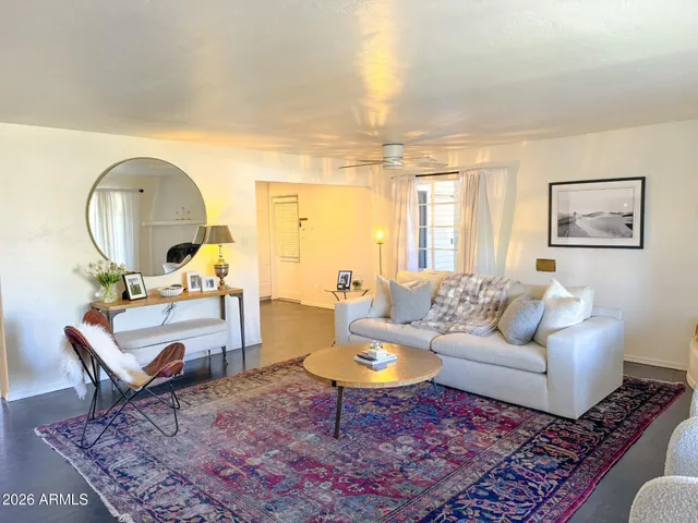 a living room with furniture a rug and a large window