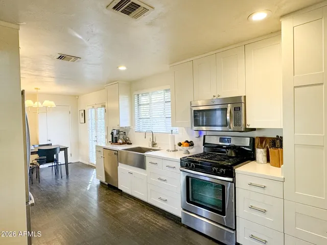 a kitchen with stainless steel appliances a stove a sink and a refrigerator