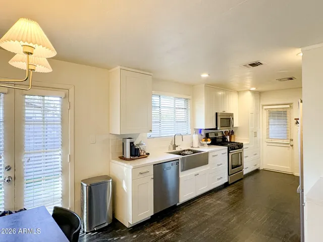 a kitchen with white cabinets and white appliances