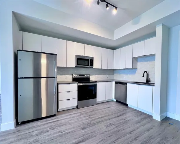 a kitchen with a refrigerator stove and wooden cabinets