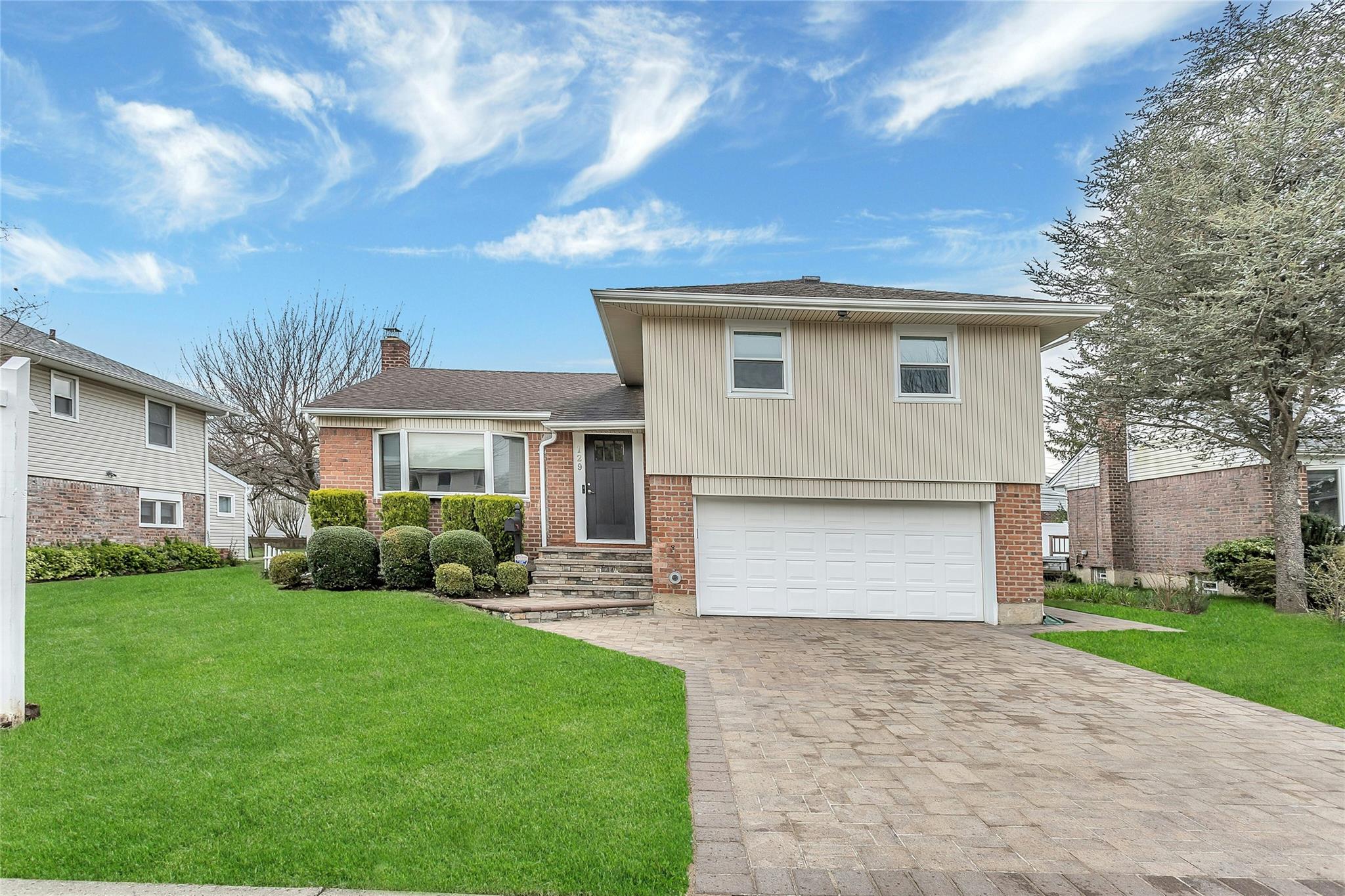 129 Manor Street Plainview, NY 11803 - Photo 1 of 1 a front view of a house with a yard and garage