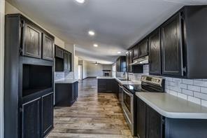 a kitchen with stainless steel appliances a sink stove microwave and cabinets
