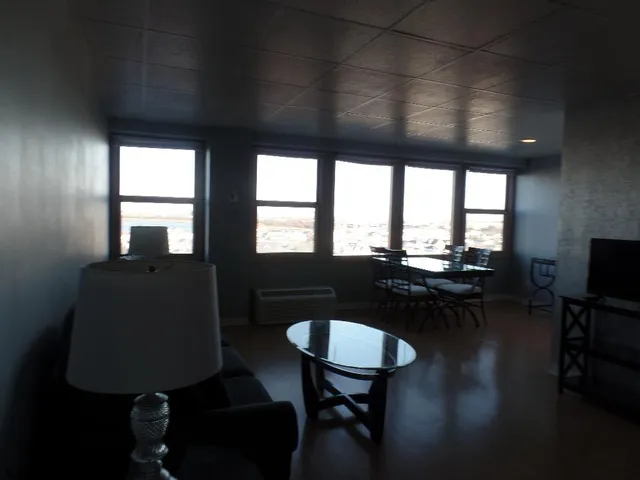 a dining room with furniture and a floor to ceiling window