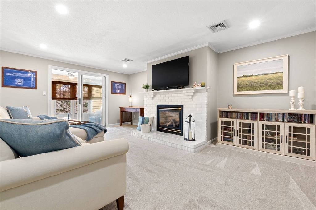 167 Village Post Road, Unit 167 Danvers, MA 01923 - Photo 5 of 42 a living room with furniture a flat screen tv and a fireplace