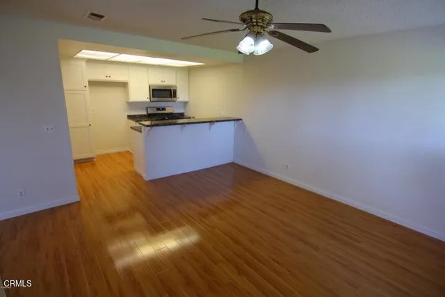 a kitchen with granite countertop stainless steel appliances and wooden floor