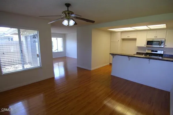 a kitchen with stainless steel appliances granite countertop a sink cabinets and wooden floor