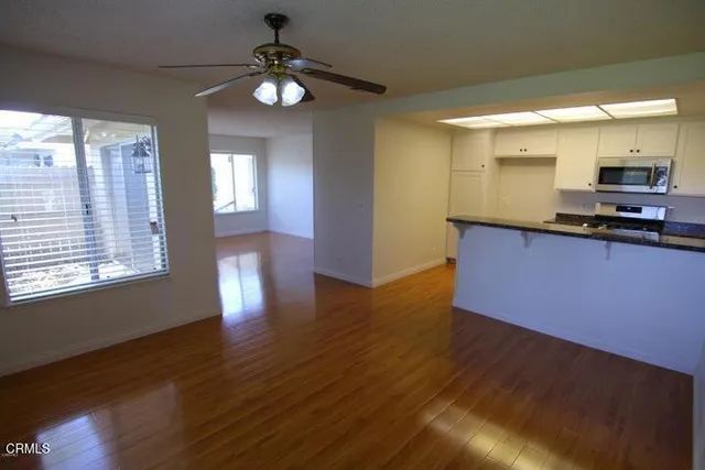 a kitchen with stainless steel appliances granite countertop a sink cabinets and wooden floor