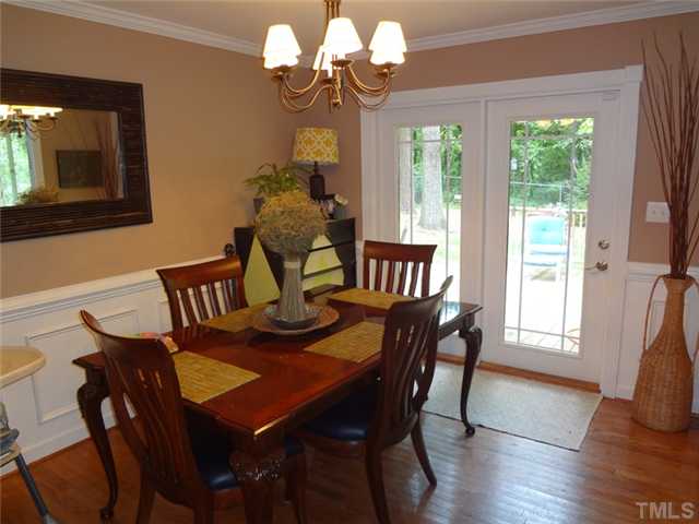 1501 Falls Church Road Raleigh, NC 27609 - Photo 3 of 25 a view of a dining room with furniture wooden floor and chandelier