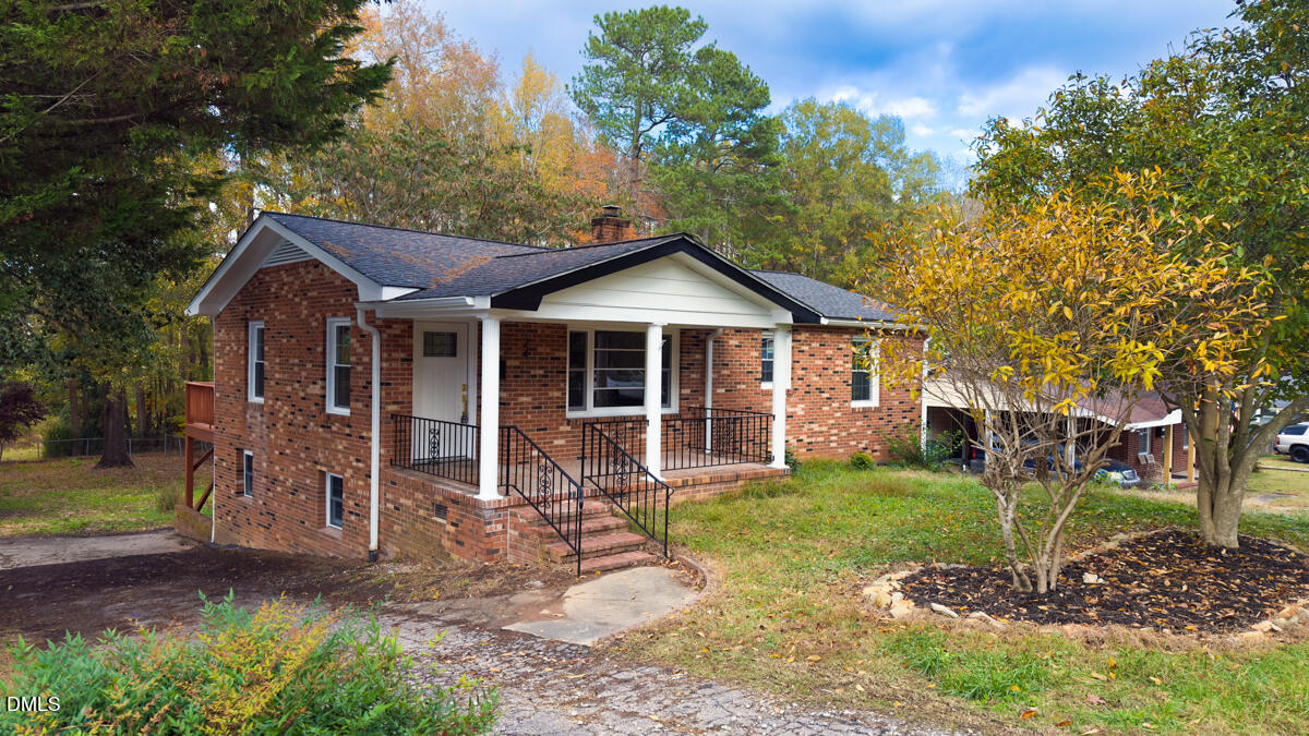 a front view of a house with a yard garden and outdoor seating