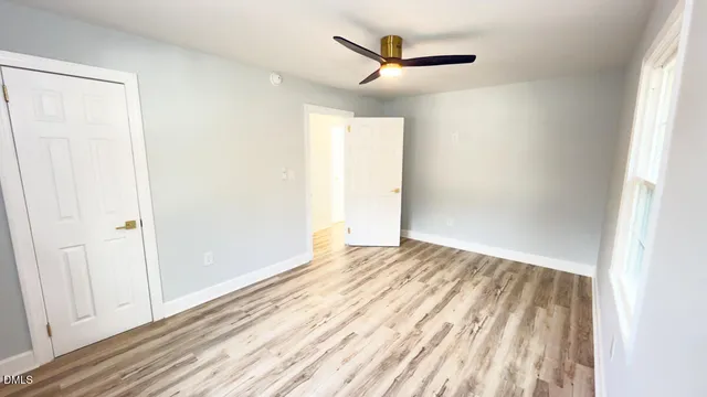 a view of a livingroom with wooden floor and a window