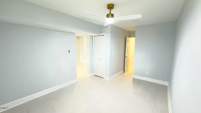 an empty room with a empty space and a ceiling fan