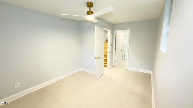 an empty room with a ceiling fan and carpet