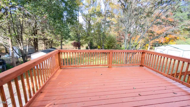 a balcony with wooden floor and trees