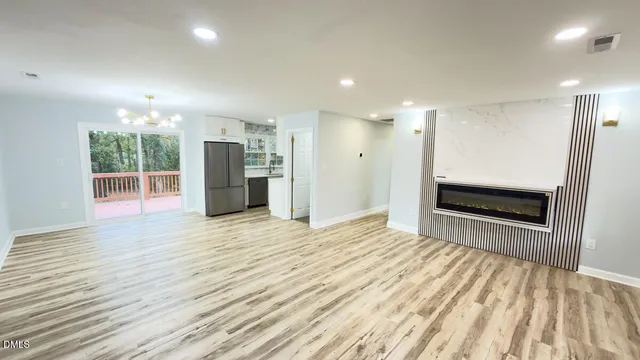 a view of empty room with wooden floor and window